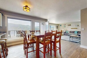 A spacious dining area with a large table and chairs, a balcony with a view, and a living area with a sofa and coffee table. - Stunning 4BR Lakefront - Dock - Balcony (Manson)