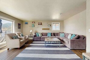A living room with a sectional sofa, a coffee table, and a striped rug. - Stunning 4BR Lakefront - Dock - Balcony (Manson)