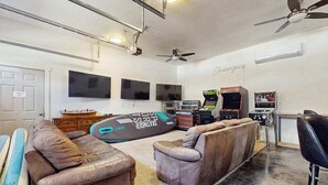 Ein Zimmer mit einer Sofagarnitur, einer Spielkonsole und einem Fernseher.