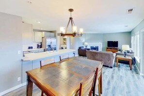 A modern kitchen with a dining area, a living room with a sofa and TV, and a large window. - 2BR Dog-Friendly - Pool (Chelan)