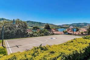 An outdoor basketball court with a clear view of the surrounding residential area and hills in the background. - 1BR Lakeview 2nd-Floor - Balcony - Pool (Chelan)