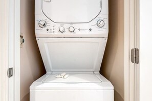 A front view of a white washing machine with control knobs and a door. - 1BR Lakeview 2nd-Floor - Balcony - Pool (Chelan)