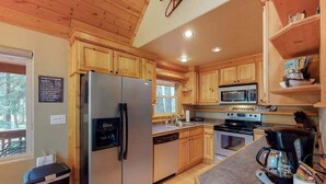 A kitchen with wooden cabinets, a stainless steel refrigerator, a microwave, an oven, and a coffee maker. - Secluded 3BR Mountainview - Hot Tub - WoodStove (Leavenworth)