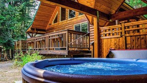 A wooden cabin with a hot tub, deck, and multiple windows. - Secluded 3BR Mountainview - Hot Tub - WoodStove (Leavenworth)