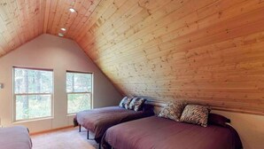 A bedroom with two beds, a sloped ceiling, and large windows. - Secluded 3BR Mountainview - Hot Tub - WoodStove (Leavenworth)