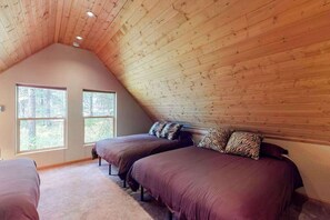 A bedroom with two beds, a sloped ceiling, and large windows. - Secluded 3BR Mountainview - Hot Tub - WoodStove (Leavenworth)