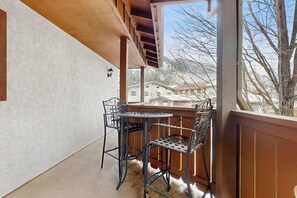 A balcony with two metal chairs and a table, overlooking a residential area. - 1 BR condo located in Icicle Village, Leavenworth (Leavenworth)
