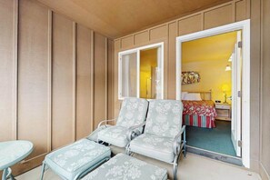 A room with a bed, a nightstand, and a chair with a floral pattern. - 1 BR condo located in Icicle Village, Leavenworth (Leavenworth)