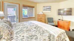 Ein Hotelzimmer mit Bett, Fernseher, Schreibtisch und Stuhl.