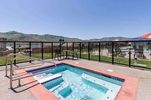 A swimming pool with a view of mountains, surrounded by a fence and outdoor seating. - Luxe 2BR - Lakeview - Patio - Pool - Hot Tub (Chelan)