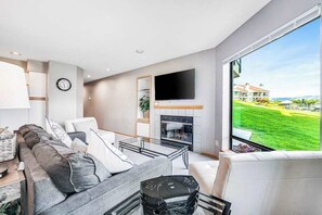 A modern living room with a sofa, coffee table, and a fireplace.