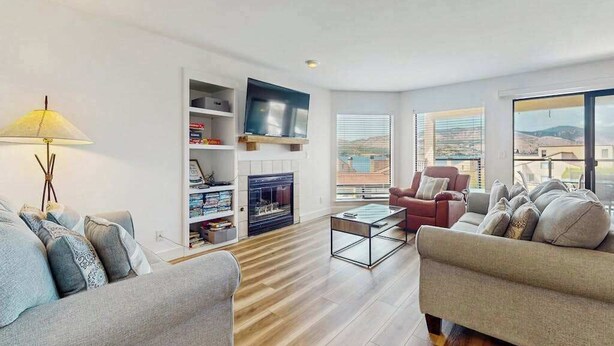 Ein modernes Wohnzimmer mit Kamin, Flachbildfernseher und einer Couch.
