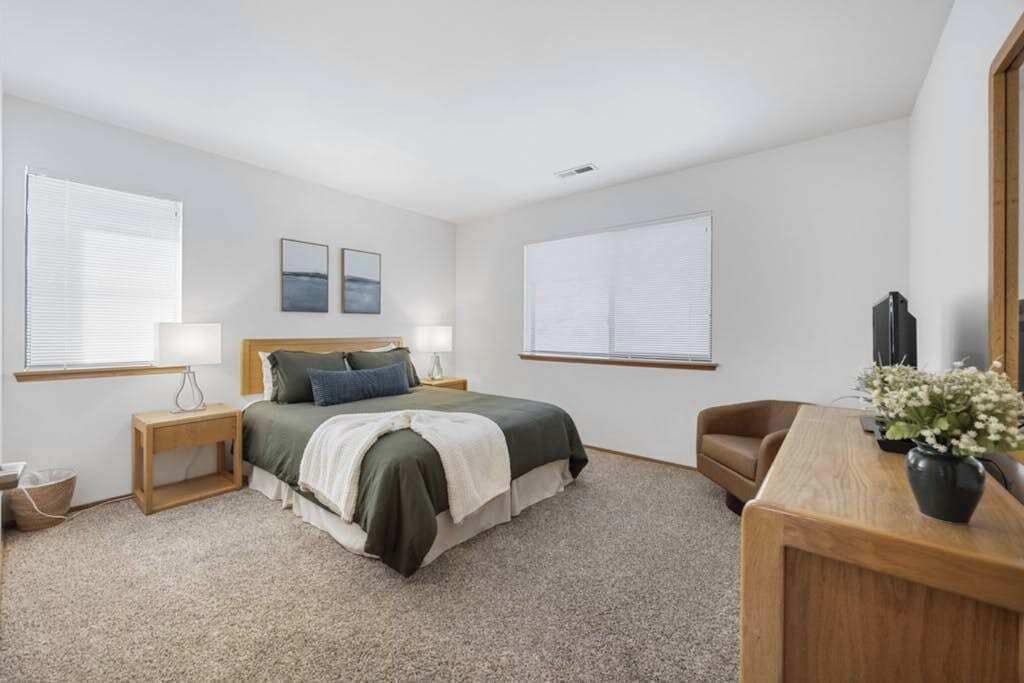 Ein Schlafzimmer mit Bett, Nachttischen, Schreibtisch und Stuhl.