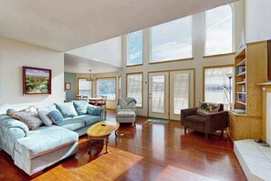 Ein geräumiger Wohnbereich mit Sofa, Sesseln, Couchtisch und Bücherregal.