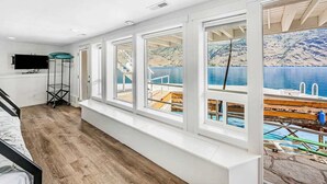 A room with a large window overlooking a dock and water. - 4BR lakefront cottage & bunk house with dock (Chelan)