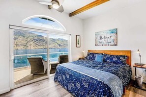 Un dormitorio con una cama grande, vista al mar, una ventana y un cartel que dice '¡Relájate! Estás en modo lago'.