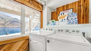 A laundry area with a view of a lake and mountains, a wooden wall, and a sign about life jackets. - 4BR lakefront cottage & bunk house with dock (Chelan)