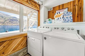 Ein Waschbereich mit Blick auf einen See und Berge, eine Holzwand und ein Schild bezüglich Schwimmwesten.
