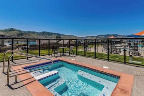 Ein Pool auf dem Dach mit Blick auf Berge, umgeben von Liegestühlen und einem Geländer.