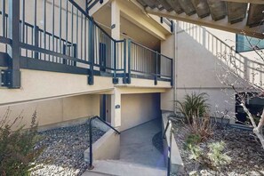 Eine mehrstufige Außenanlage mit Treppe, Geländern und einem kleinen Garten mit Pflanzen und Steinen.