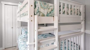 A bunk bed with patterned bedding, a white door, and a white railing. - Walk to Downtown 3BR Lakeview - Hot Tub - Deck (Manson)