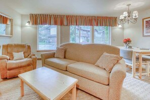 A living room with a sofa, armchairs, a coffee table, and a dining area with a table and chairs. - Downtown 2BR Mountainview 1st-Floor - Patio (Leavenworth)