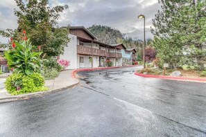 A building with a balcony, a red curb, and a mountain in the background. - Downtown 2BR Mountainview 1st-Floor - Patio (Leavenworth)