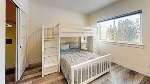 A child's bedroom with a bunk bed, a dresser, and a window. - 3BR water view home with deck & open layout (Manson)