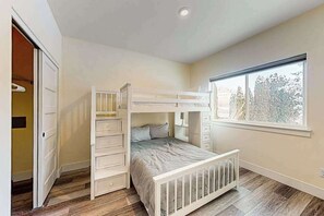 A child's bedroom with a bunk bed, a dresser, and a window. - 3BR water view home with deck & open layout (Manson)