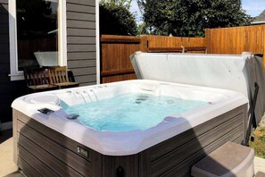 Ein Whirlpool mit Holzverkleidung, einer Steuerung und einer integrierten Sitzgelegenheit.