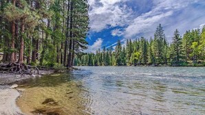A river with clear water, surrounded by dense forest and tall trees. - Light-filled 3BR Dog Friendly - Deck (Leavenworth)