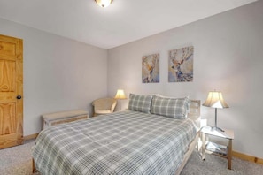 A bedroom with a bed, two bedside lamps, a chair, and two wall art pieces. - Light-filled 3BR Dog Friendly - Deck (Leavenworth)