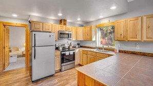 A modern kitchen with wooden cabinets, stainless steel appliances, and a large island. - Light-filled 3BR Dog Friendly - Deck (Leavenworth)