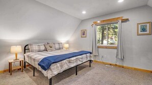A bedroom with a bed, bedside lamps, a window with curtains, and a framed picture on the wall. - Light-filled 3BR Dog Friendly - Deck (Leavenworth)
