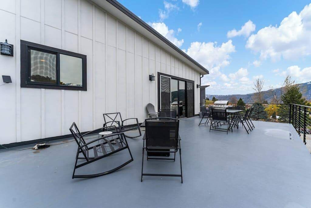 A rooftop patio with outdoor furniture and a glass door leading to an interior space.