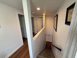 A staircase with a handrail, wooden flooring, and white walls. - Whisper Valley Villa. New Remodel. Hot Tub! Fenced back yard, High speed WiFi. (Eureka)
