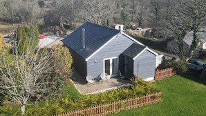 A single-story house with a sloped roof, a fenced yard, and a clear view of the surrounding landscape.