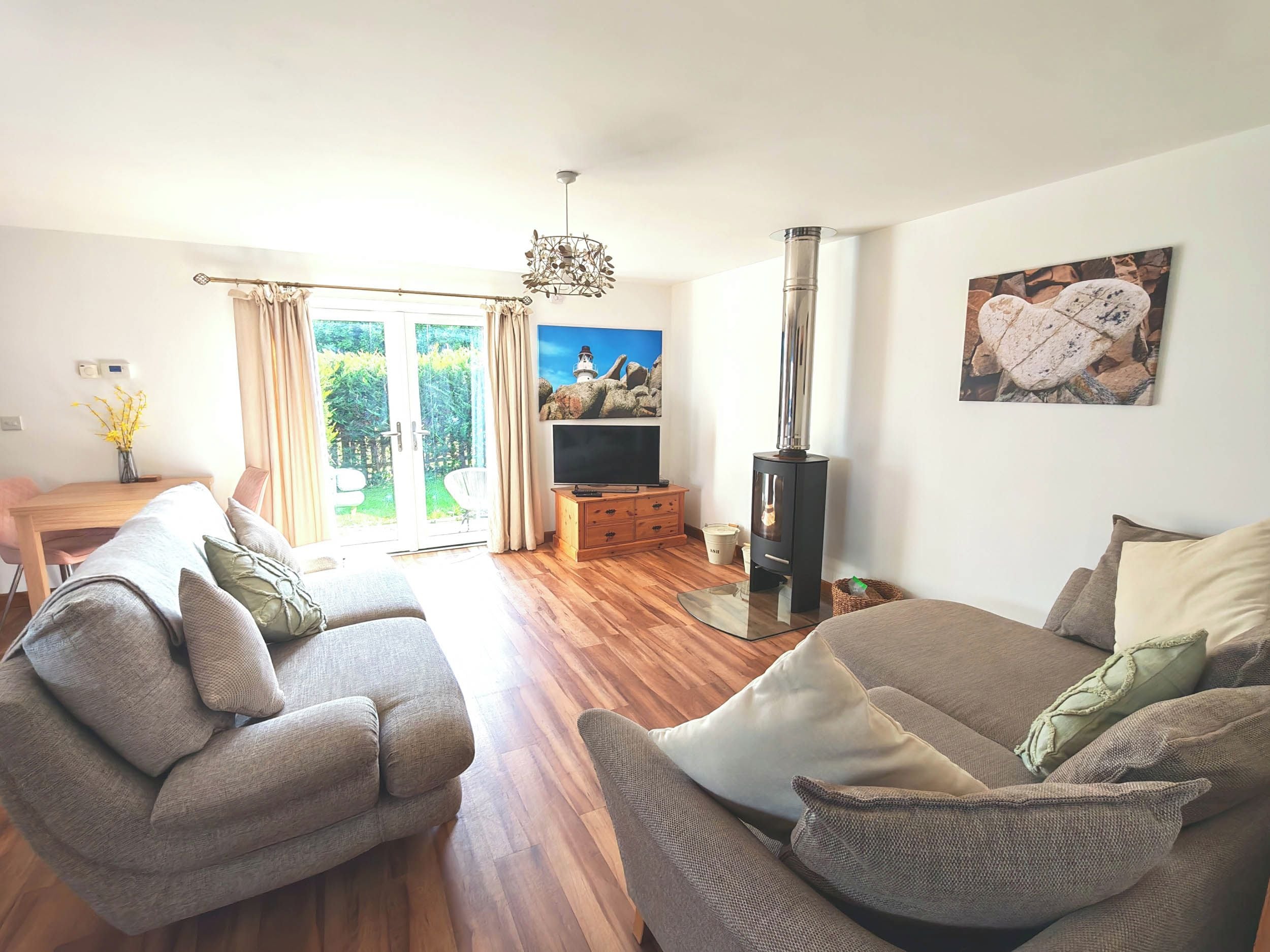 A living room with a sofa, a television, a fireplace, and a dining area with a table and chairs.