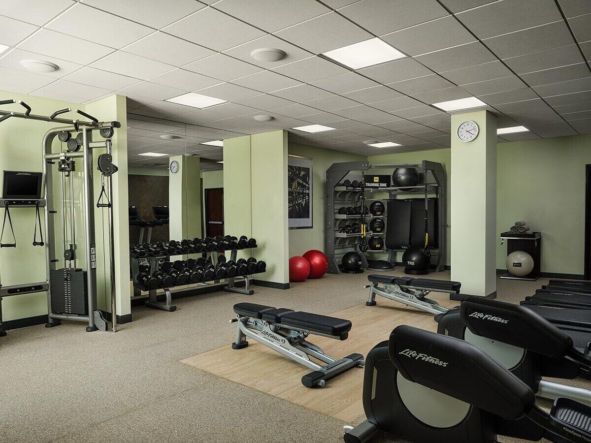 A gym with treadmills, weight machines, and free weights.