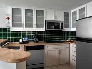 A kitchen with white cabinets, a microwave, a dishwasher, and a refrigerator. - Cancun One Bedroom Villa Westin Lagunamar Resort (Cancún)