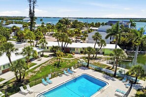 Zona residencial amb piscina, palmeres i vistes al mar.
