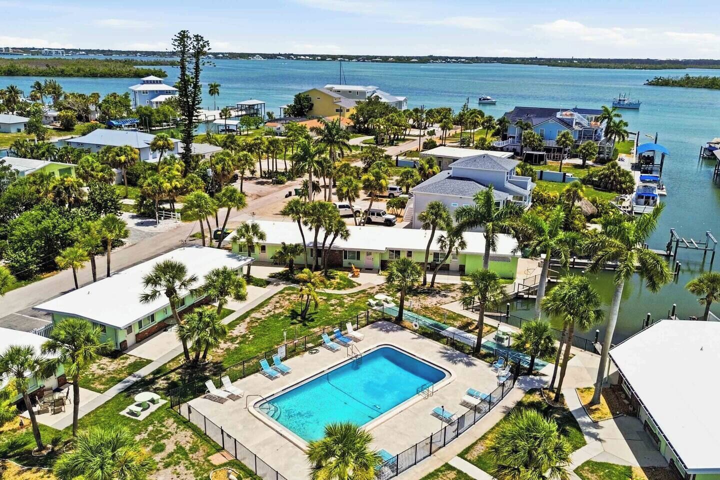 A resort with a swimming pool, palm trees, and a marina.