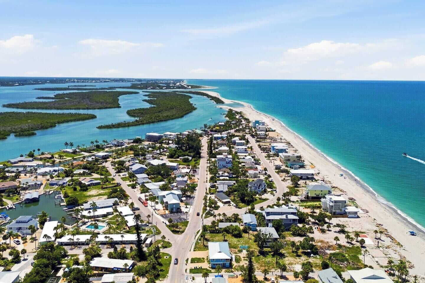 Une zone résidentielle côtière comprenant des maisons, une plage et un port de plaisance.