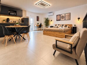 Un espacio habitable moderno con comedor, sofá, cama y cocina.
