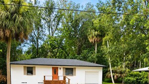 Ein einstöckiges Haus mit Veranda, Garage und einem gepflegten Rasen.