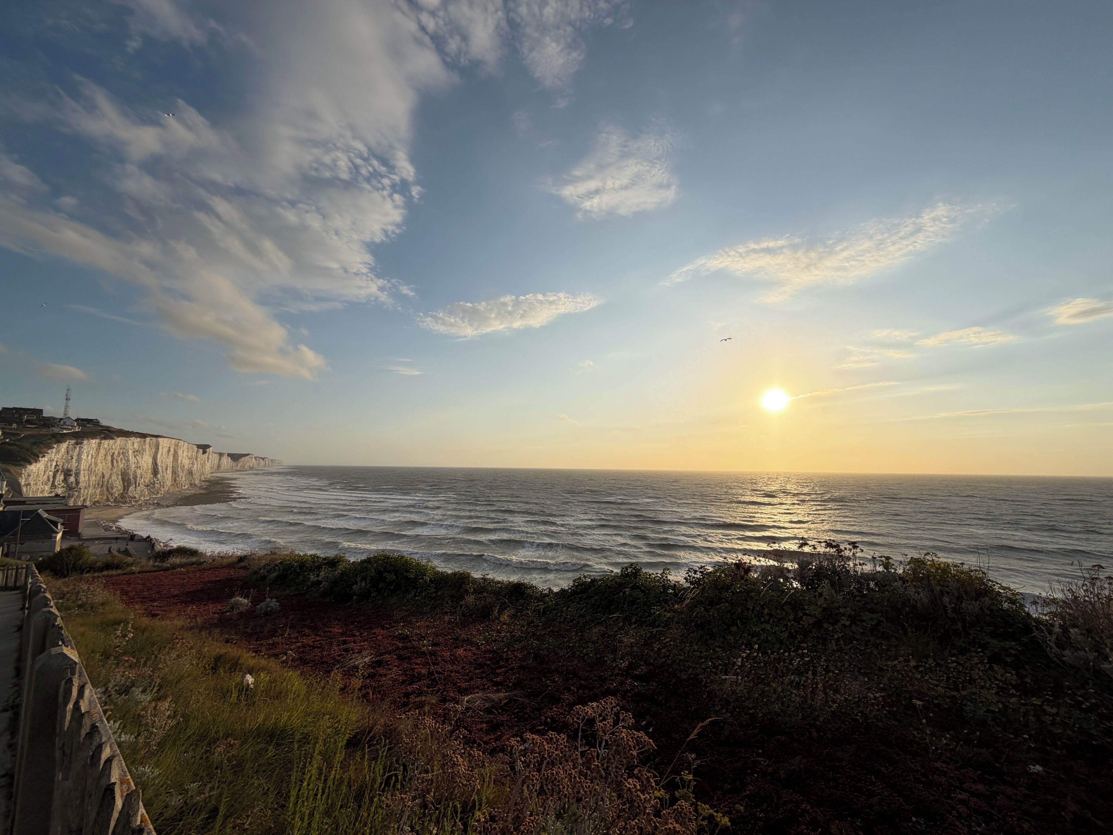 A coastal landscape with cliffs, a beach, and the ocean.