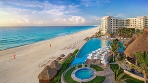 Un resort con piscina, spiaggia e edifici dell'hotel.