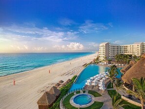 Ein Resort mit Pool, Strand und Hotelgebäuden.