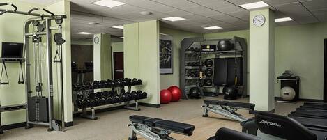 A gym with treadmills, weight machines, and free weights.