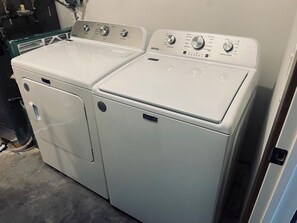 A white Maytag front-loading washer and dryer set with control knobs and a digital display. - Courtside Cabin
Gym- Hot Tub- Events (Nisswa MN)